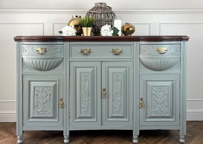 antique Edwardian carved detail sideboard. Hand painted in a soft sage green mineral paint and sealed with a semi Matt varnish. The top trim has been sanded and stained with a dark wood stain. The original brass handles and hinges have been polished to a high shine
