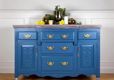 Antique hand carved Edwardian oak sideboard. Hand painted in a vivid mid blue mineral paint and sealed with a Matt varnish for a subtle sheen. The antique brass drawer and door handles have been polished to a high shine. The top of the sideboard and feet have been sanded and stained with a white furniture oil